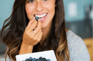 Beautiful woman eating blueberries 300x197