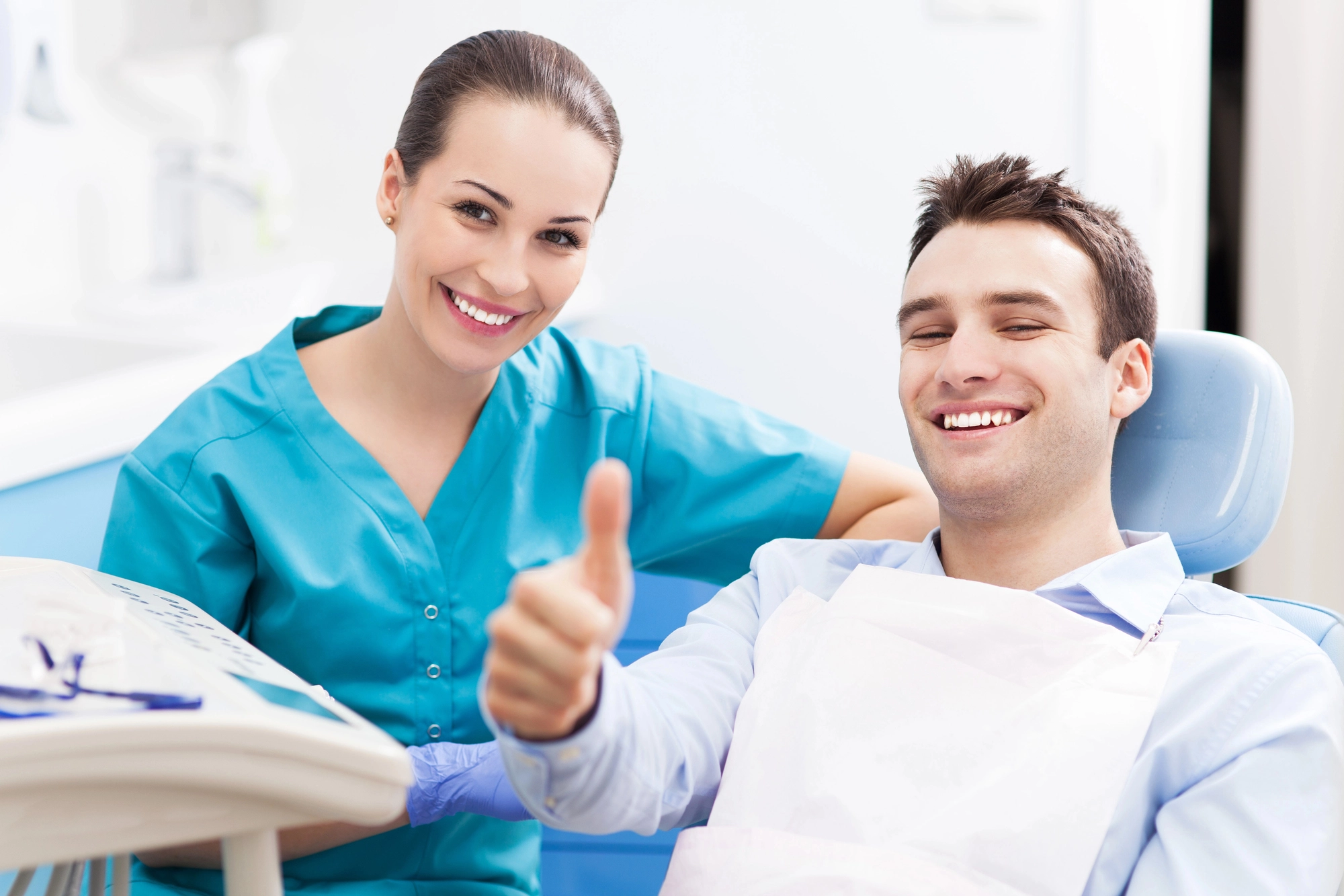 dentist and patient smiling at camera and doing a thumbs up after receiving sedation dentistry in Arlington